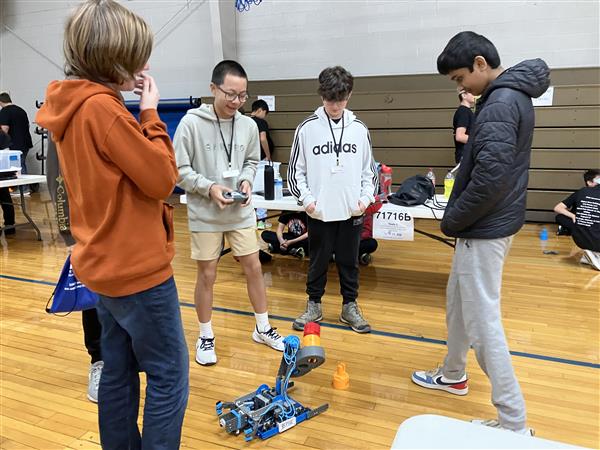 Students stand around a robot.